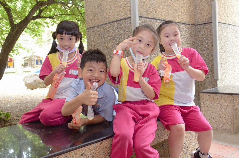 學童捐發票換冰棒，開心吃著冰棒，盡情享受歡樂的兒童節